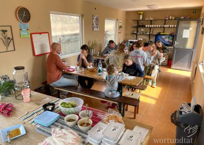 Small room with several dining tables and a counter with food
