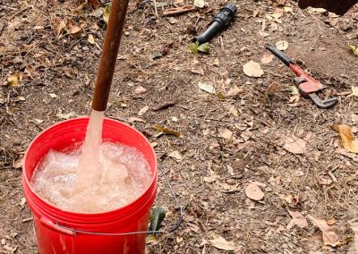 Ein Rohr aus dem mit hohem Druck Wasser in einen Eimer fließt