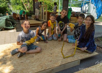 Children with tools on a wooden board - helping children in Germany
