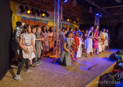 many children and young people in costumes on one stage - helping children in Germany