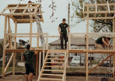Vier Männer arbeiten am fast fertigen Klettergerüst