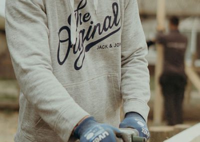 Mann bearbeitet Balken mit Bandschleifer