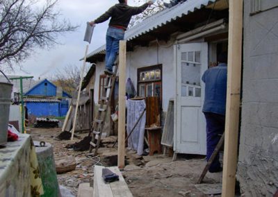 Construction crew repairing roof of a house