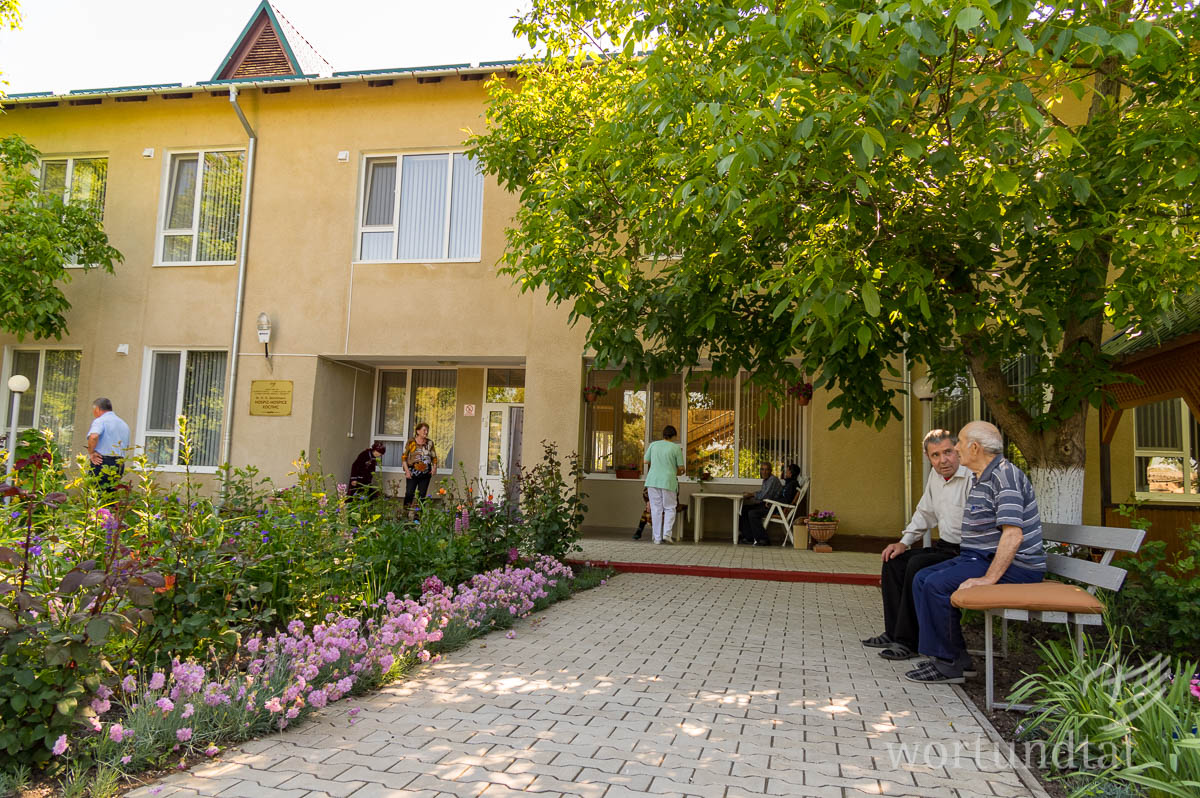 Im landesweit ersten Hospiz verbringen Menschen ihre letzten Lebenswochen. In Orten, in denen es diese Hilfe nicht gibt, sterben viele Menschen allein zuhause ohne professionelle Begleitung. Arzt hält Jungen im Arm und horcht dabei die Lunge ab. Junge verzieht das Gesicht.