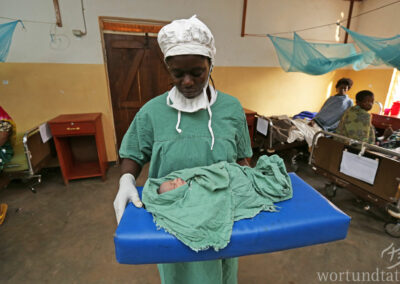 Hebamme mit Neugeborenem