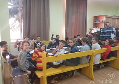 Children sitting around a table and looking at the camera