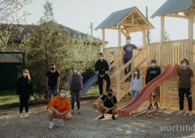 ehrenamtliche Helferinnen und Helfer posieren vor fertigem Klettergerüst