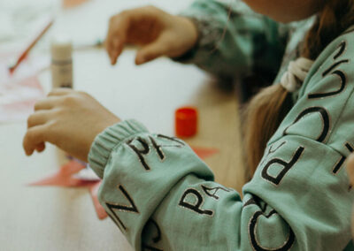 ein Kind bastelt mit Papier und Kleber