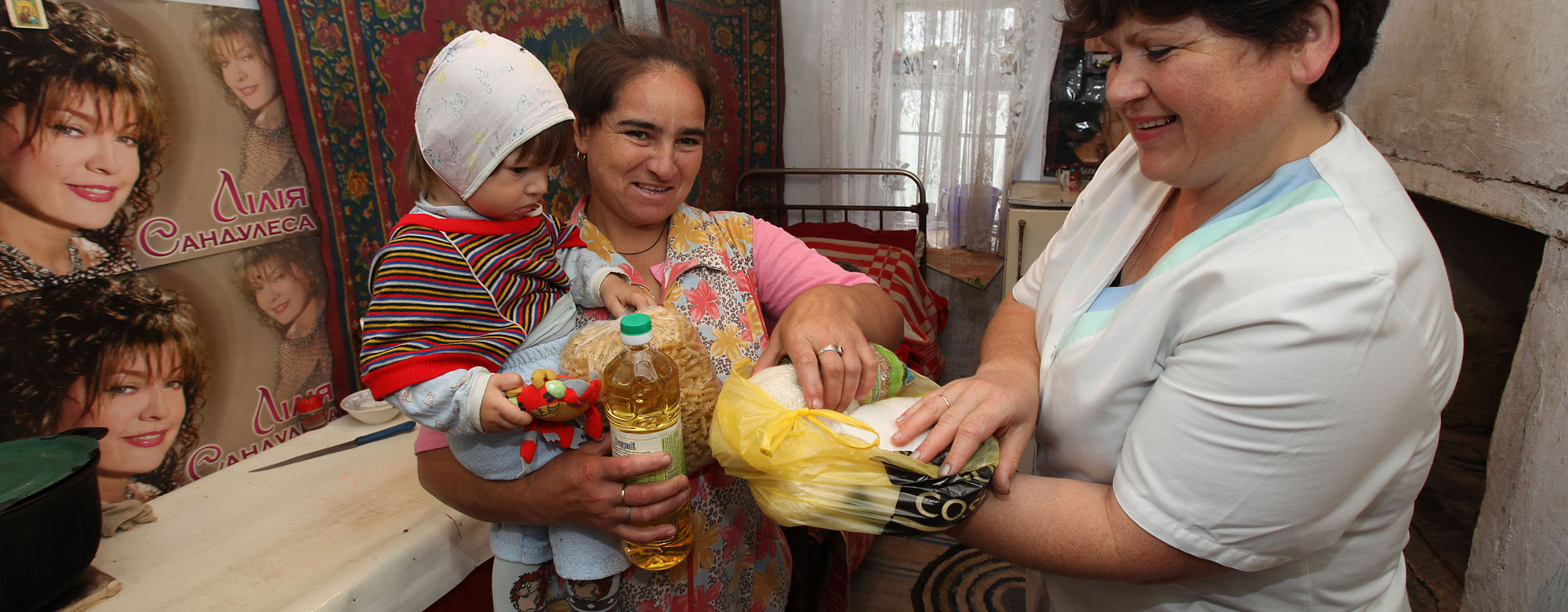 Helferin übergibt Lebensmittel an Frau mit Kind - wortundtat - Republik Moldau Helferin übergibt Lebensmittel an Frau mit Kind