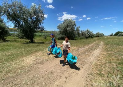 Two boys with filled rubbish bags on a country lane
