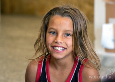 Ca. 7-jähriger Junge mit langem Haar, lachend