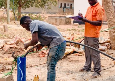 Two men carrying out the final work on a well