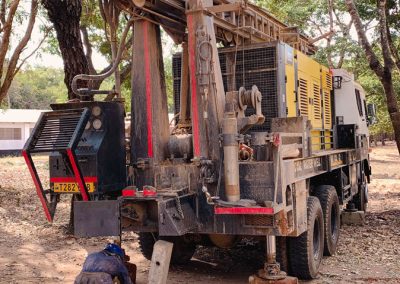 A worker prepares the site where the machine should drill for water